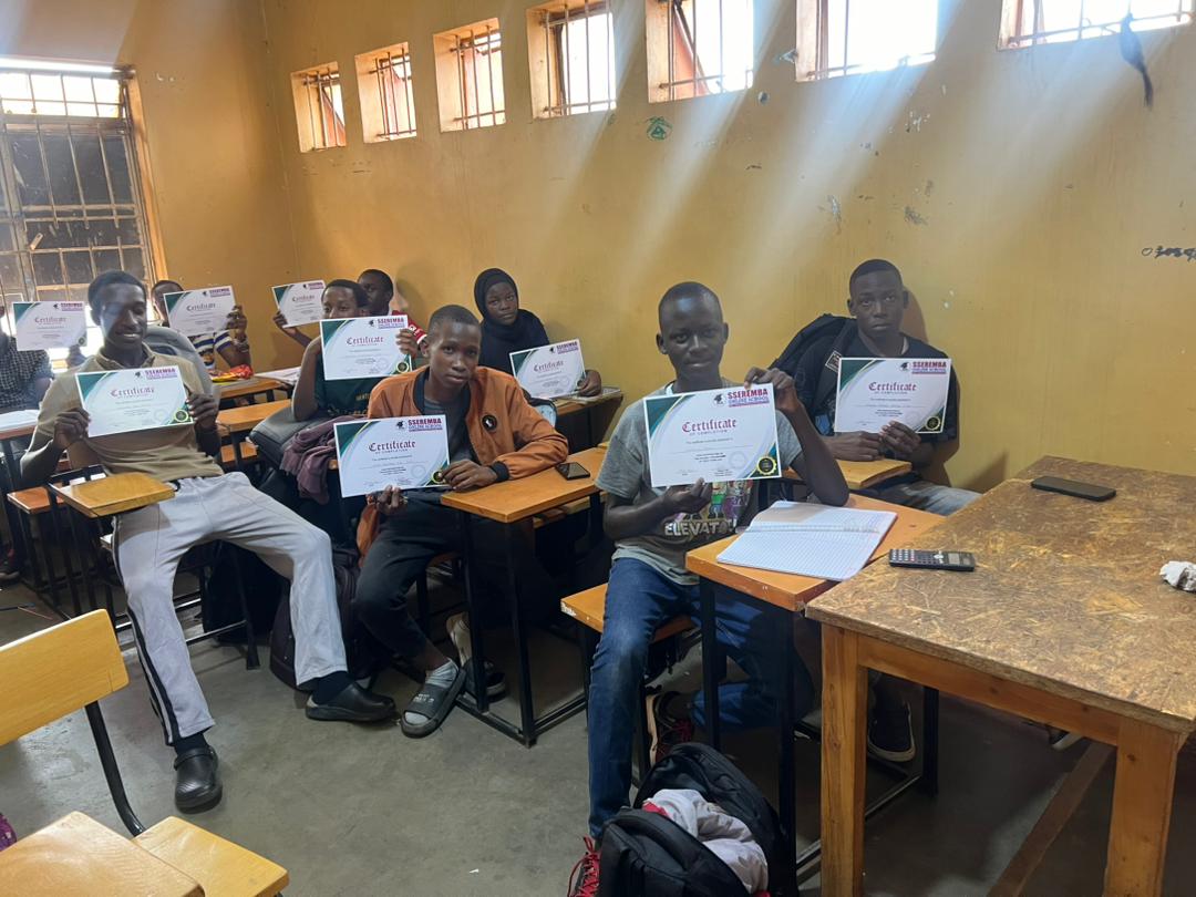 Sseremba students holding completion certificates in class