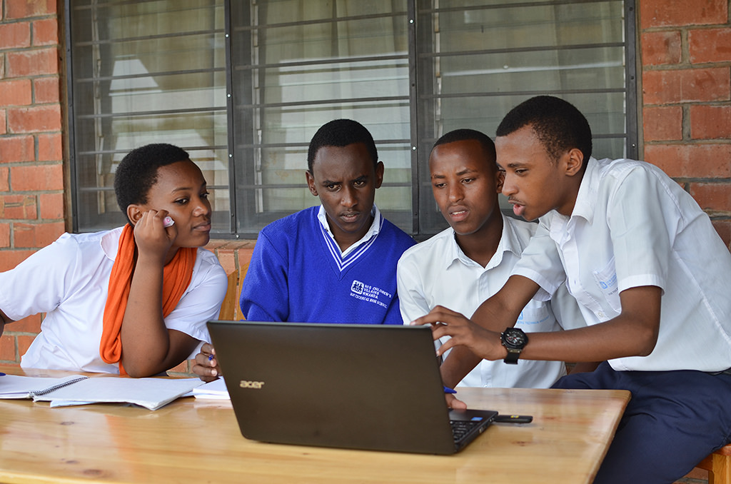 Sseremba students reviewing a lesson together on a laptop